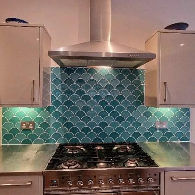 Kitchen splashback with teal fish-scale tiles.