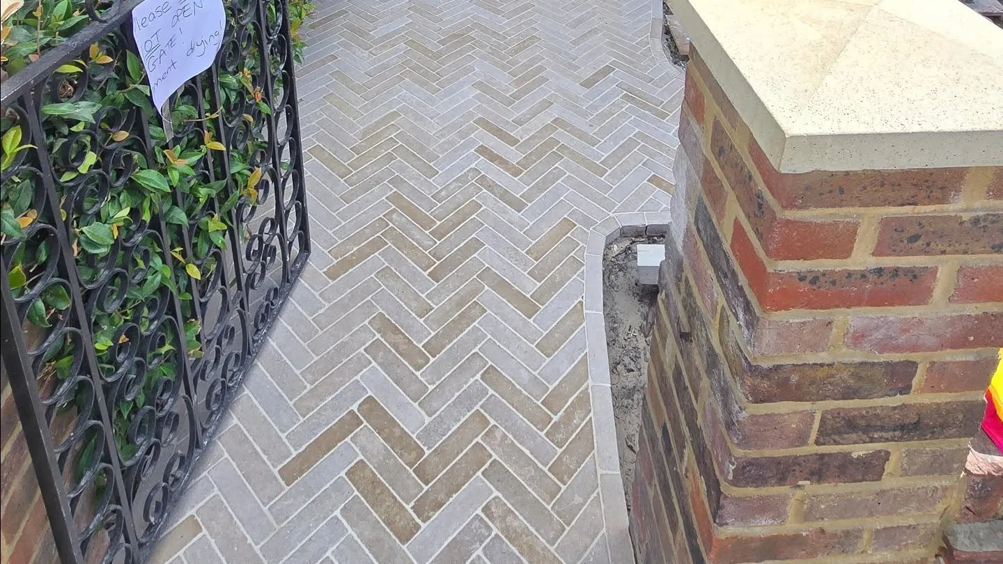 Exterior entrance path tiled in a herringbone pattern.