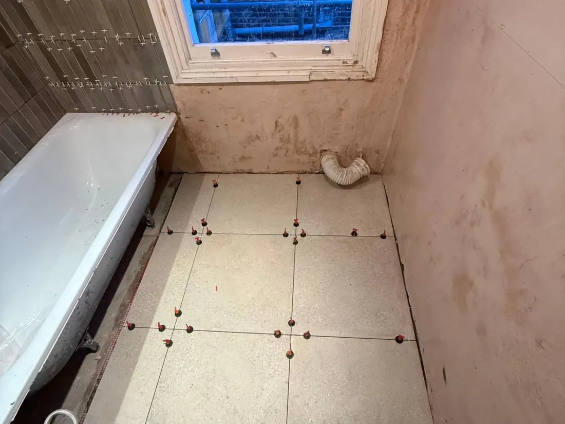 Large-format floor tiles with levelling clips during installation.