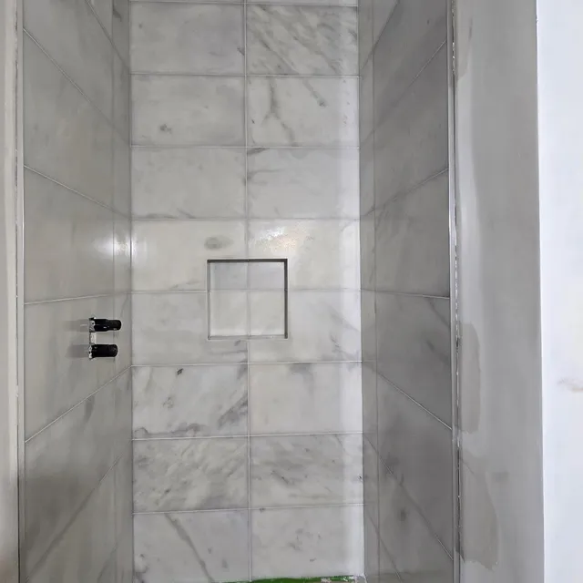 Marble-effect shower niche detail.