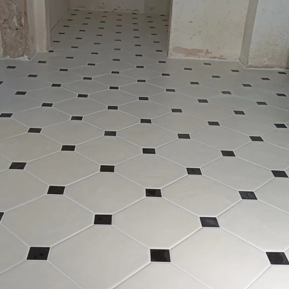 Floor mosaic of octagon and small square tiles laid on a diagonal.