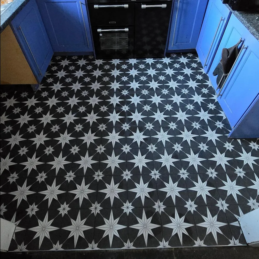 Kitchen floor tiled in a bold black-and-white geometric star pattern.